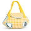 Yellow checkered bunny carrier backpack bag held by hand, structured rabbit travel harness with ear openings, white background